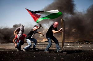 Palestinian youth walk towards Israeli soldiers, during clashes following a protest commemorating the Nakba, outside Ofer military prison, near the West Bank city of Ramallah, May 15, 2012.